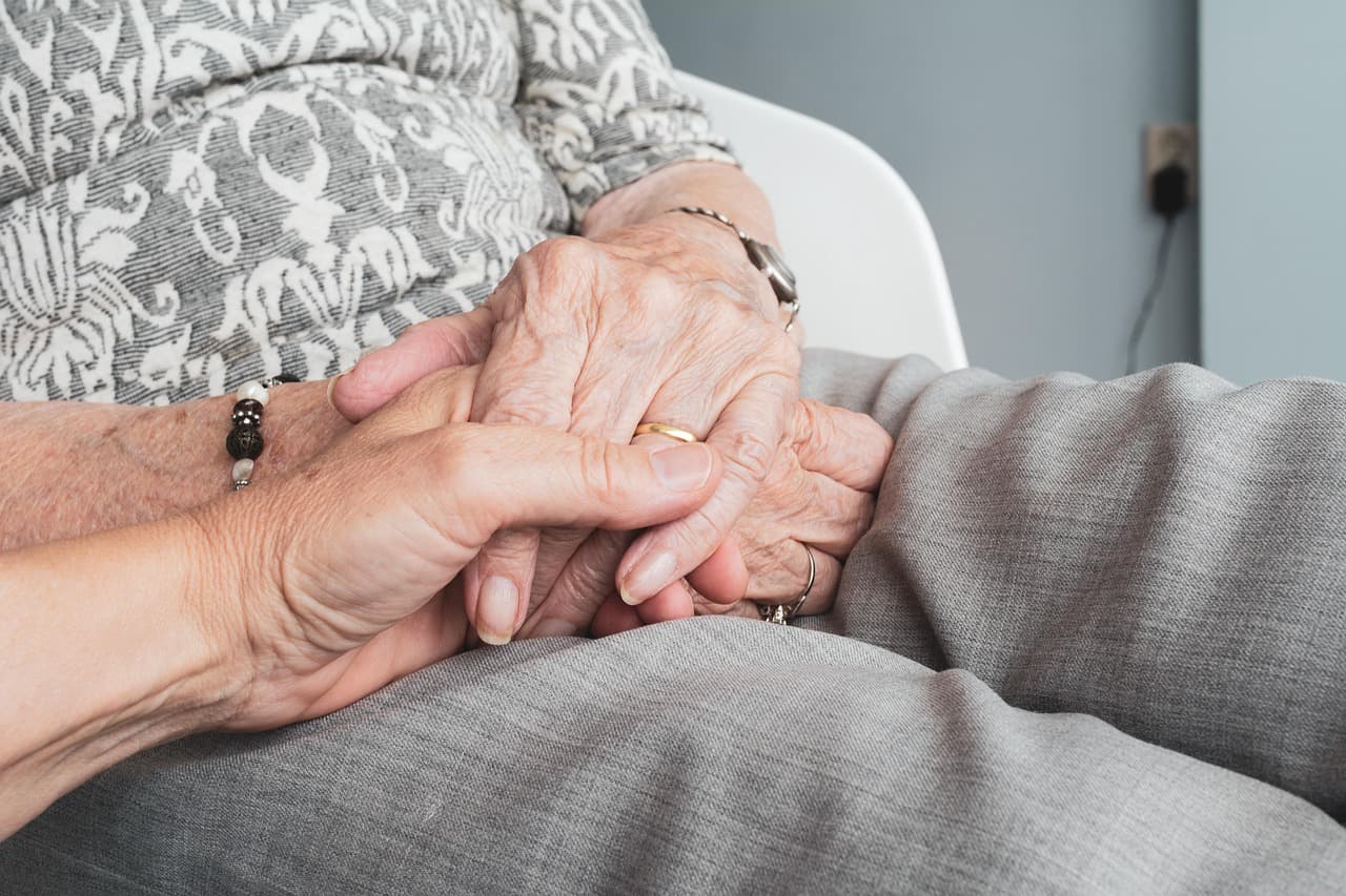 Two people holding hands, a quiet moment between family
