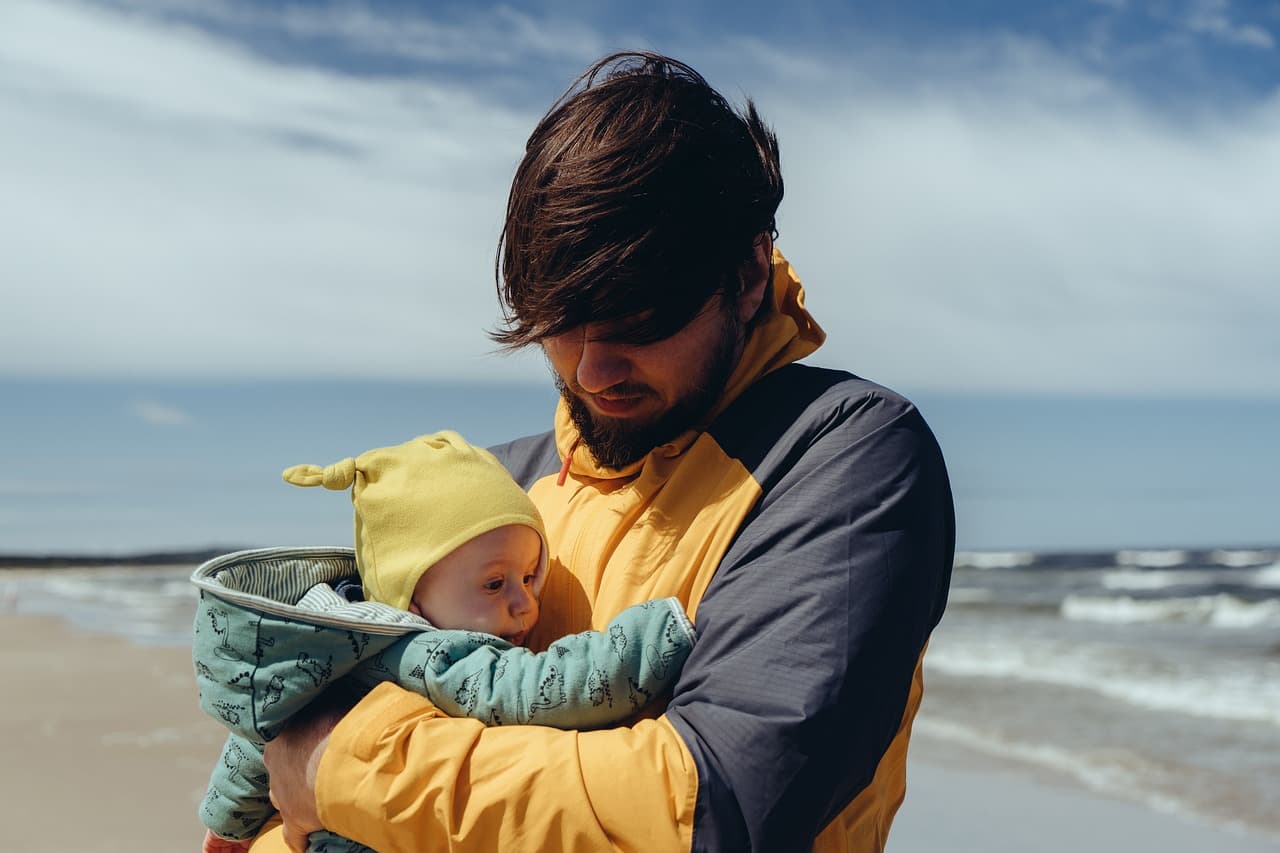 A father holding his baby on the beach
